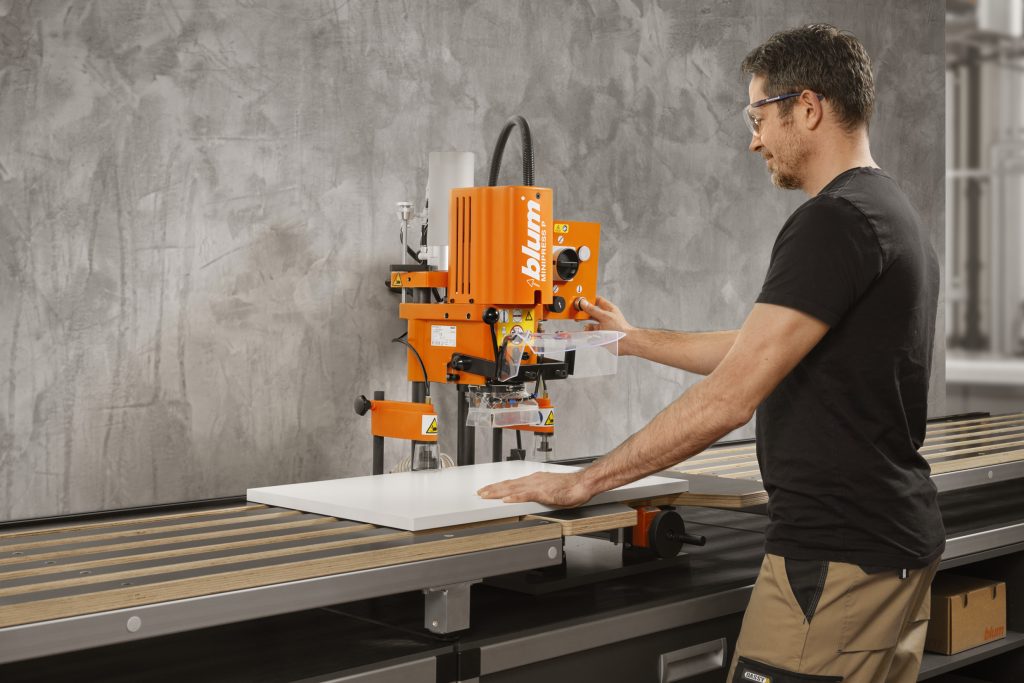 Man using a Blum Minipress P in a cabinet shop