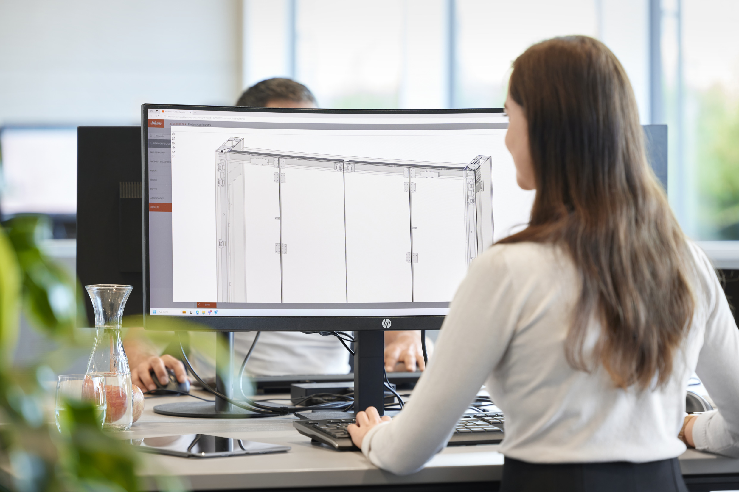 Woman sitting in front of a computer screen and using the Blum product configurator